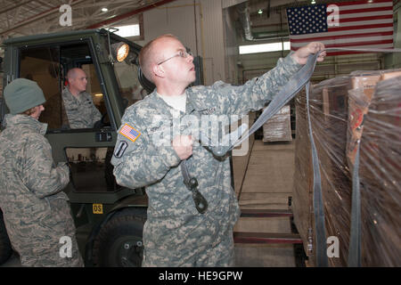 West Virginia National Gardist, Spc Josh Higginbotham, zugeordnet der 77. Brigade 201. vorwärts Unterstützungskompanie, fesselt eine Palette, wie eine andere Palette auf der Roll-off in einem Hangar am 167. Airlift Wing, Martinsburg, W.VA, Nov.2, 2012 gelegt wird. 167. AW dient als Stagingbereich für Katastrophe Hilfsgüter, die dann in West Virginia transportiert wird, je nach Bedarf. Die Nationalgarde von West Virginia hat über 200 Mitglieder, die Beihilfe bei der Wiederaufnahme Bemühungen von Hurrikan Sandy.  Der Sturm mit starkem Schneefall und regen bedeckt und hatte auch starke Winde, die Links Stockfoto