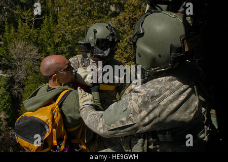 US Armee Sgt. Jason Townsen, Fluglehrer, und Sgt. Nathan McLaughlin, eine Standardisierung Lehrer von Firma C, 1-171 Medevac, Utah Army National Guard, West Jordan, Utah, Rettung verloren Wanderer, Staff Sgt Christian Larsen, ein Sanitäter aus C Company, 1-171 Medevac, Utah Army National Guard, West Jordan, Utah, während einer Suche und Rettung Training Übung auf Lager W.G. Williams, Riverton , Am 3. April 2012 in Utah. Stockfoto