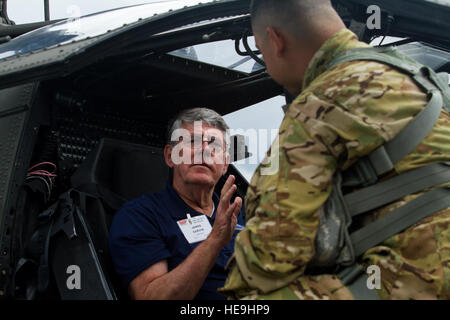 Ein US-Soldat, 16. Combat Aviation Brigade, 7. Infanterie-Division, Gespräche, ein Vietnam-Veteran, sitzen in einem Hubschrauber Apache AH-64E während eines Besuchs bei Joint Base Lewis-McChord, Wash., 20. Mai 2016 zugewiesen. Der böse Skipper-Verein ist eine Gruppe von Vietnam-Ära-Flieger, die mit Delta Company, 2. Bataillon, 8. Kavallerie-Regiment, 1. Kavallerie-Division (Airmobile) serviert. Stockfoto