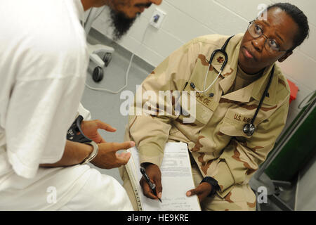 GUANTANAMO BAY auf Kuba – Navy Lt. CMdR Angela Stallworth, ein Amtsarzt mit Joint Task Force Guantanamo gemeinsame Praxisgemeinschaft, hört ein Häftling während einer Routineuntersuchung, 9. Juli 2010. Die JMG bietet medizinische Versorgung zu den Häftlingen in Guantanamo JTF. JTF Guantanamo bietet sichere, humane, legale, transparente Pflege und Obhut der Gefangenen, einschließlich der Militärkommission und die verurteilten freigegeben von einem Gericht angeordnete. Die JTF führt Intelligenzansammlung, Analyse und Verbreitung für den Schutz von Insassen und Personal arbeitet in JTF Guantanamo Einrichtungen und Unterstützung Stockfoto