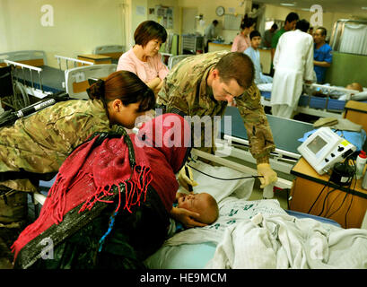 Major Marcus Neuffer, 455. Expeditionary Praxisgemeinschaft Augenarzt und seine Techniker, Airman 1st Class Chellbie Gonzales, führen eine Ultraschalluntersuchung auf dem linken Auge eines 12-Monats-jungen im koreanischen Krankenhaus auf Bagram Air Field, Afghanistan, Juli 7. Neuffer ist derzeit der einzige Arzt auf Bagram, der Augen operieren qualifiziert ist. Wenn ein lokaler Patient zu eines der humanitären Krankenhäuser, das koreanische oder ägyptischen Krankenhaus kommt und muss von einer Augenoperation, werden sie im amerikanischen Krankenhaus gebracht. Nach Nueffer hält ein Kind Sehvermögen entwickelt sich etwa acht. Wenn korrigierende Überspannungsschutz Stockfoto