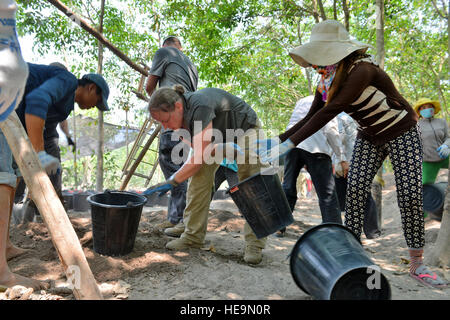 US Army Staff Sgt Samantha Brenneman, Defense POW/MIA Accounting Agentur (DPAA) Erholung Unteroffizier, ergänzt bewegt Eimer Schmutz mit einheimischen Arbeitern in Tay Ninh Provinz, Vietnam, 24. März 2016. Brenneman ist Spezialist Leichenhalle Angelegenheiten zugewiesen, die 2. Brigade Brigade Unterstützungsbataillon, 2nd Stryker Brigade Combat Team, 2. US-Infanteriedivision stationiert am Joint Base Lewis-McChord, Wash Sie ist Teil eines spezialisierten Teams bereitgestellt durch DPAA auf der Suche nach zwei Service-Mitglieder im Jahr 1967 bei einem Flugzeugabsturz l-19 verloren. Die DPAA Mission besteht darin, den Zügen möglich Buchhaltung fo Stockfoto