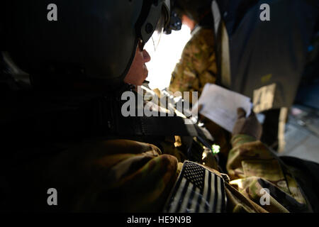 US Army Major Mario Rivera, 159. Combat Aviation Brigade unterwegs Intensivpflege Krankenschwester, liest eine 9-Zeile während des Fluges für Patiententransport in Afghanistan, Juli 2014. Rivera, ein Eingeborener von Añasco, Puerto Rico, in der Regel von Fort Campbell, Kentucky Medevac Crews bereitgestellt wird, gehören zwei Piloten, eine Krankenschwester und ein Crew-Chief. Auch kann mit einer Krankenschwester unterwegs Intensivpflege fliegen.  Senior Airman Sandra Welch) Stockfoto