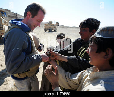 Jim Moore, Department of State Süd- und Zentralasien Bureau stellvertretender Staatssekretär für Presse- und Öffentlichkeitsarbeit, Hände Süßigkeiten zu Kuchi Nomaden jungen während seines Besuchs in Tepe Sardar, Afghanistans einzigartiges Denkmal der sakralen Architektur außerhalb Stadt Ghazni, November 17. Mitglieder von Ghazni Provincial Reconstruction Team und State Department haben zwei archäologische Stätten besucht. In Ghazni 2013 blicken, Brainstorming im Jahr feiert Ghazni zur islamischen Kulturhauptstadt der asiatischen Welt, US-Botschaft von Public Affairs und Moore wie Ghazni Provinz besser zu unterstützen, da es darum bemüht, identifizieren Stockfoto