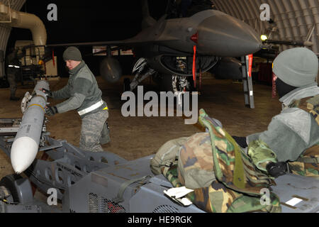 Senior Airman Vasiliy Zorin Führer eine Rakete in Richtung einer f-16 Fighting Falcon ausüben als Senior Airman Vincent Gleffe eine Bombe Gabelstapler während fährt Beverly Mitternacht 13-1 auf Kunsan Air Base, Südkorea, 14. Januar 2013. Die Crew arbeitete schnell, um die f-16 Fighting Falcon Kampf bereit für die Generation zu machen. Zorin und Gleffe sind 8. Aircraft Maintenance Squadron Waffen laden Crew-Mitglieder. Senior Airman Marcus Morris) Stockfoto