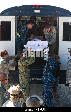 US-Flieger, Soldaten und Matrosen entlasten Simulationspatienten aus einem Bus um am 21. Juni 2012 während der Übung GLOBAL MEDIC 2012 an Bord einer C - 130 H Hercules-Flugzeuge und auf weitere Versorgung geladen werden.  Übung GLOBAL MEDIC 2012 ist eine jährliche gemeinsame Feld Trainingsübung für Theater aeromedical Evakuierungssysteme und Boden medizinische Komponenten entwickelt, um alle Aspekte der medizinischen Kampfunterstützung zu replizieren.  Techn. Sgt Erica J. Knight Stockfoto