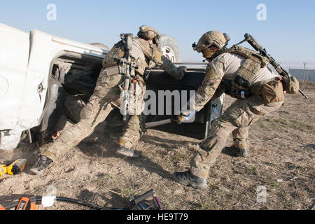 Pararescuemen aus der 83. Expeditionary Rescue Squadron arbeiten zu entfernen, die Tür eines zerstörten Fahrzeugs und kostenlos einen Dummy simuliert einen Unfall während einer Bergung Übung in Bagram Air Field, Afghanistan, 23. Januar 2016. Die Übung erlaubt Service-Mitglieder aus der 83. ERQS und Craig Joint Theater Krankenhaus hier Gelegenheit, ihre Reaktion auf reale Notfallszenarien zu üben. Techn. Sgt. Robert Cloys) Stockfoto