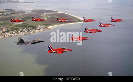 Eine f-22 Raptor fliegt mit Kunstflugstaffel der britischen Royal Air Force, The Red Arrows, während des Fluges 18 Juni über Langley Air Force Base, VA., Praxis für eine Flugschau Juni 20. Staff Sgt Samuel Rogers) Stockfoto