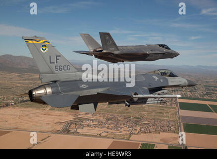 Major Justin Robinson fliegt das 56. Betriebsgruppe Flaggschiff f-16 Fighting Falcon 10. März 2014, als er die erste f-35 Lightning II zu seinem neuen Haus Luke Air Force Base, Arizona Escort Die f-35 wurde von Colonel Roderick Cregier, eine f-35-Testpilot auf der Edwards AFB stationiert geflogen, Kalifornien Robinson ist 61. Fighter Squadron Assistant Director of Operations. Jim Hazeltine) Stockfoto