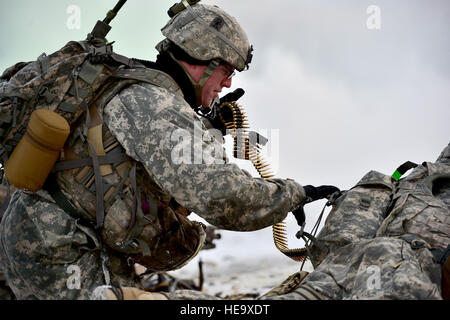 Army Staff Sgt Samuel Hammer, zugewiesene Baker Company, 3. Bataillon, 509. Fallschirm-Infanterie-Regiment, 4th Infantry Brigade Combat Team (Airborne), 25. Infanterie-Division, U.S. Army Alaska zieht Maschinengewehr Munition aus einem anderen Fallschirmjäger Pack bei live-Feuer und Bewegung-Kontakt auf die Infanterie Kader Kampf Kurs auf gemeinsamer Basis Elmendorf-Richardson, Alaska, Dienstag, 8. November 2016. Die Soldaten konzentriert sich auf Kernkompetenzen Infanterie wie z. B. Team Bewegung, Kommunikation, wechselnden Feuer und einmal auf das Ziel identifiziert und Waffenlager Beseitigung und Behandlung von Feuer und Stockfoto