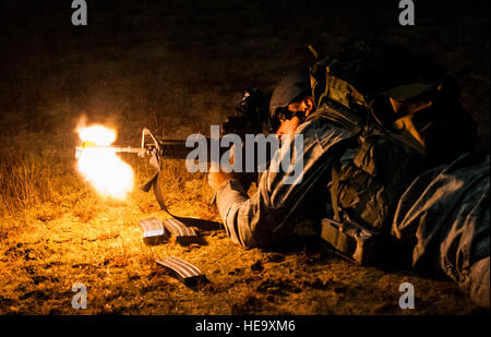 Flieger 1. Klasse Jacob Albers, 1st Combat Kamera Squadron Fotojournalist, feuert seine M4 Karabiner-Gewehr mit einem Schalldämpfer auf der Vorderseite auf die feindlichen Streitkräfte während der Nacht taktische Trank der Fähigkeit zu überleben und zu betreiben Übung 14. Januar 2014, im Norden Hilfs Flugplatz, S.C 1. Bekämpfung der Kamera Staffel befindet sich am gemeinsamen Basis Charleston, SC, veranstaltete die Fähigkeit zu überleben und betreiben Übung Jan. 6-17.  Senior Airman Dennis Sloan) Stockfoto