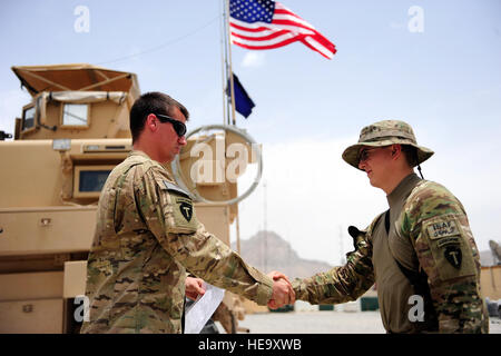 US Army 1st Lt. Brandon Bowden, Zugführer, gratuliert Spc. Michael Richeal, Security Force Medic für provinzielle Rekonstruktion Team Farah, während seine erneute Eintragung Zeremonie bei nach vorn Operating Base Farah, Afghanistan 30 Mai. Richeal ist ein combat Medic aus Alaska, der zuständig für die Behandlung und die Sicherheit seiner Mitkämpfer PRT ist.  Staff Sergeant Jonathan Lovelady) Stockfoto