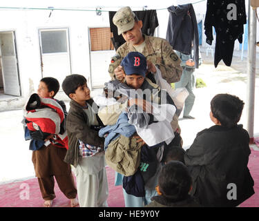 Provinz KANDAHAR, Afghanistan--US Feldprediger (Capt) Antonio Garcia-Mendez, 385th Polizei Bataillon Militärseelsorge bereitgestellt von Fort Stewart, Georgia, händigt Hüte für Kinder bei einem Besuch in der Frauen und Kinder Teil Sarposa Gefängnis Dez. 3. Die weibliche Engagement-Team und Mitglieder des Lagers Nathan Smith versammelt Kleidungsstücke und Hygieneartikel übergeben an die Frauen und Kinder aus. Senior Airman Sean Martin, Kandahar Provincial Reconstruction Team) (veröffentlicht) Stockfoto