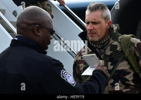 U.S. Customs and Border Protection Agent überprüft die Identifizierung eines Mitglieds der französischen Luftwaffe (FrAF) vor der ersten trilateralen Übung Langley Air Force Base, VA., 1. Dezember 2015. Ca. 325 britische Royal Air Force und FrAF Personal reiste in die USA zur Teilnahme an der Übung.  Senior Airman Aubrey weiß) Stockfoto