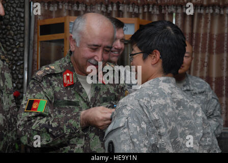 KABUL, Afghanistan--Afghanischen Generalmajor Amin Ullah Karim, Commander, Afghan National Army Training Command, US Army Staff Sgt Jennifer Marcos, Afghan National Army weiblich Officer Candidate School Lehrer, mit einem US-Army Achievement Medal während einer Preisverleihung, 22. September 2010 präsentiert. Sergeant Marcos wurde neben ihrem Fellow U. S. und afghanischen weiblichen Ausbilder für die Ausbildung der ersten Klasse ANA weiblich Officer Candidate Schulen anerkannt. Staff Sgt Laura R. McFarlane Stockfoto