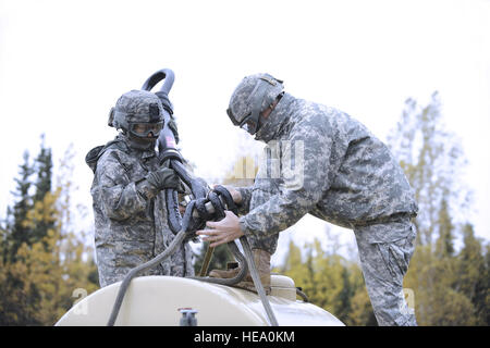 PFC. Natalie Mehring (links), Phoenix, Arizona, und Staff Sgt Adam Hipwell von San Jose, Kalifornien, sichern ein Kabel zu einem Wasser-Anhänger wie Soldaten aus der Forward Support Unternehmen, 6. Pionier-Bataillon, Slingload Operationen mit dem 1. Bataillon, 207. Aviation Regiment, Alaska Army National Guard bei Landing Zone Ranger, JBER-Richardson, 20. September 2012 durchzuführen. Die Soldaten waren verantwortlich für die Einrichtung der Landezone, rigging ein High Mobility Multipurpose Wheeled Vehicle und Wasser Trailer für Slingloading und Kommunikation mit einem UH - 60L Black Hawk-Hubschrauber im Rahmen des Stockfoto