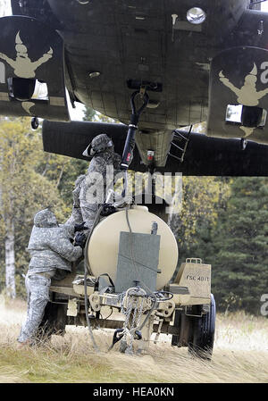 PFC. Natalie Mehring, vorwärts Unterstützungskompanie, 6. Pionier-Bataillon von Phoenix, Arizona, verbindet ein Kabel zu einem schwebenden Hubschrauber UH - 60L bei Slingload Operationen mit dem 1. Bataillon, 207. Aviation Regiment in Alaska Army National Guard bei Landing Zone Ranger, JBER-Richardson, 20. September 2012.  Die Soldaten waren verantwortlich für die Einrichtung der Landezone, rigging ein High Mobility Multipurpose Wheeled Vehicle und Wasser Trailer für Slingloading und Kommunikation mit dem Hubschrauber als Teil der Einheit Kompetenz bei der Bereitstellung kritischer Versorgungsgüter und Ausrüstungsgegenstände von rotary Flugzeug Stockfoto