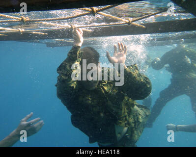 Ein US-Marine schwimmt unter einer Leiter in der Wüste überleben Französischkurs des Wasser Hindernis-Parcours, in der Nähe von Arta Strand, Dschibuti, 30. September 2015. Neben dem Erlernen der Überlebenstaktiken, zusammengetan zwei Soldaten der US Army Civil Affairs Bataillon, zugewiesen kombiniert Joint Task Force-Horn von Afrika, französische Armee Soldaten aus dem 5. Übersee kombiniert Arme Regiment, und Mitglieder des 15. Marine Expeditionary Unit, um eine Reihe Hindernisse während der 14-Tage-Kurs absolvieren.  Senior Airman Nesha Humes) Stockfoto