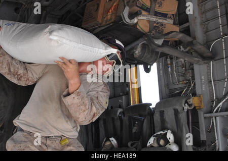 U.S. Marine Corps Lance Cpl. Anthony Marino, Marine Tilt Rotor Squadron 266 verstärkt (VMM-266-Lauf), 26. Marine Expeditionary Unit Kraftstoff Linie Walker, ein Beutel mit Mehl World Food Programme Hilfe aufteilen Seite 12 Okt. in der Nähe von Pano Aqil Cantonment, Pakistan, entlastet. US-Hubschrauber Hilfsaktionen seit 5. August, mehr als 12 Millionen Pfund Essen in abgelegenen Gebieten in der transportiert wurden Links Hilfe nach einem Hochwasser ca. 1/5 der Grafschaft unter Wasser auf ihrem Höhepunkt. Zu, Fuelers, Hubschrauber zu gewährleisten wurden trugen angeheizt und flugbereit. Von t Stockfoto