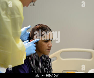 Lieutenant Colonel David Jones, 455. Expeditionary Praxisgemeinschaft Kinderarzt bereitet sich auf ein 12-Year-Old Boy Kopf im Craig Joint Theater Krankenhaus auf Bagram Air Field, Afghanistan, Okt. 20 untersuchen. Der junge vor kurzem hatte eine Operation zu helfen, Druck auf sein Gehirn zu entlasten und für eine Infektion behandelt wird. Jones ist ein Eingeborener von San Antonio, Texas.  Staff Sergeant Stephenie Wade) Stockfoto