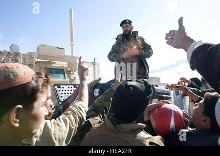 Afghan National Army Soldaten verteilen Fußbälle und Luftpumpen, Dorfbewohner Tandan Dorf, Afghanistan, Jan. 25. Der Direktor der Landwirtschaft, Bewässerung und Viehzucht, Niaz Mohammad Lali Zadron und ANA Soldaten verteilten Schaufeln, Radios, Rucksäcke, Essen, warme Kleidung und andere Lieferungen in der kalten Bergdorf im Rahmen einer afghanischen Regierung Outreach-Mission.   US Air Force Personal Sgt. Barry Loo, Paktya Provincial Wiederaufbau Team Public Affairs) Stockfoto