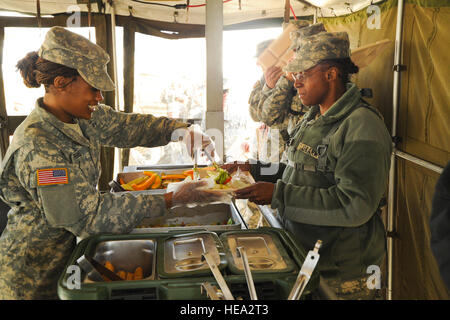 US Army Lt. Col Malinda Coakley vom 48. Combat Support Hospital immer etwas warmes Abendessen am Fort Hunter Liggett, Calif., 14. Mai 2011, zur Unterstützung der Global Medic 2011. Globale Medic ist ein gemeinsames Feld Trainingsübung für Theater aeromedical Evakuierung System und Boden medizinische Komponenten entwickelt, um alle Aspekte der medizinischen Kampfunterstützung zu replizieren.  Techn. Sgt Chris Hibben Stockfoto