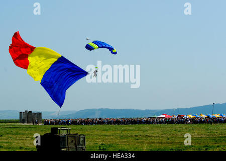 Ein Fallschirmspringer schwebt auf den Boden und dabei ein großer rumänische Flagge vor Hunderten von Zuschauern während der rumänischen Luftwaffe 71. Air Base Flugschau und Tag der offenen Tür am Campia Turzii, Rumänien, 23. Juli 2016. Die Luftfahrt-Demonstration fand statt in der Mitte von der US-Luftwaffe 194. Expeditionary Fighter Squadron sechs Monate lang Theater Sicherheit Paketbereitstellung nach Europa zur Unterstützung der Operation Atlantic zu beheben, die darauf abzielt, den USA Stärken weiterhin Engagement für die kollektive Sicherheit der NATO und Hingabe an den dauerhaften Frieden und Stabilität in der Region. Das Gerät Stockfoto