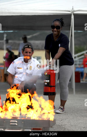 GUANTANAMO BAY auf Kuba – Naval Station Guantanamo Bay Fire Inspector John DiGiovanni gibt Army Staff Sgt Monique Gold eine praktische Demonstration, wie man richtig mit einen Feuerlöscher während Naval Station Guantanamo Bay National Night Out, 3. August 2010. Gold wird mit Joint Task Force Guantanamo bereitgestellt. JTF Guantanamo bietet sichere, humane, legale, transparente Pflege und Obhut der Gefangenen, einschließlich der Militärkommission und die verurteilten freigegeben von einem Gericht angeordnete. Die JTF führt Intelligenzansammlung, Analyse und Verbreitung für den Schutz von Gefangenen und personn Stockfoto