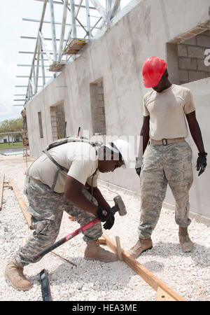 US Armee SGT Timothy Puckett, eine Zimmerei und Mauerwerk-Spezialist, bereitgestellt von der Louisiana National Guard 1023rd vertikale Ingenieur-Unternehmen, unterstützt eine US Air Force-Ingenieur mit Verlegung Rahmen einen konkreten Bürgersteig 13. Mai 2014, an der Hattieville Regierung School in Hattieville, Belize gießen. BDF und US-Service-Mitglieder arbeiten zusammen, um neue Horizonte Belize 2014 fünf Schulgebäude und eine medizinische Einrichtung in Belize zu bauen. New Horizons ist eine jährliche Veranstaltung koordiniert zwischen den USA und dem Gastgeberland zu gegenseitigen Ausbildungsmöglichkeiten in den Bereichen Gesundheit Auto Stockfoto