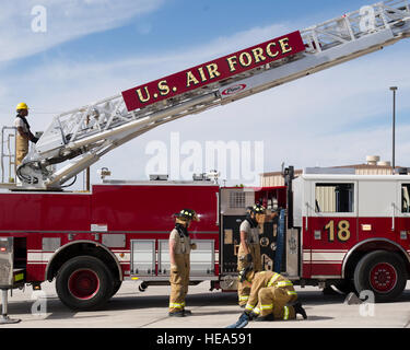 Holloman Fire Emergency Services Flieger wickeln Sie eine Antwort-Demonstration in Fire Prevention Woche Holloman Air Force Base, N.M., Okt. 7. Eine Leiter Crew besteht aus einem Crewchief, wer ist verantwortlich für die gesamte Crew und zeichnet sich durch einen roten Helm, eine Treiber-Betreiber, der ist der Treiber und die Leiter, ein Lineman, wer ist verantwortlich für ziehen den Feuerwehrschlauch, und ein Plugman, wer ist verantwortlich für die Feuer-Verbindungsschlauch zum LKW betreibt.  Staff Sgt E'Lysia Wray Stockfoto