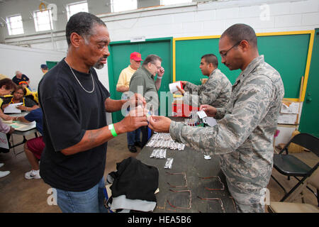 Public Health Officer 1st Lt. Gyasi J. Mann, rechts, und bioenvironmental Engineer Senior Airman Emilio D. Gonzalez, zweiter von rechts, beide mit der 108. Medical Group, New Jersey Air National Guard Hilfe Obdachlosen Veteranen wählen Sie ein paar Lesebrille während Stand Down 2012 bei der National Guard Armory in Cherry Hill 28. September 2012.  Die New Jersey Department of Military und Veterans Affairs zusammen mit Soldaten der Nationalgarde von New Jersey und Flieger und die stehen unten von South Jersey Ausschuss, Inc. Co-Gastgeber Stand Down um bereitzustellen, dass Obdachlose Veteranen mit Zugang zur Gesundheitsversorgung, geistige heilen Stockfoto