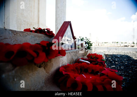 Mohn Kränze und eine US-Flagge sitzen auf ein Denkmal nach Ihrem Eingang dort durch Militärangehörige und Zivilisten aus Großbritannien, Frankreich, USA und anderen Staaten während einer Zeremonie am Remembrance Day Sonntag, 13. November, in dem Dschibuti neuen europäischen Friedhof. Die 850 Gräber auf dem christlichen Friedhof sind diejenigen gehören zu 13 Männer, die während des Dienstes in der britischen, kanadischen und australischen Truppen während des zweiten Weltkriegs gestorben. Stockfoto