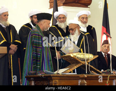 041207-F-5586B-025 Afghanistans Präsident Hamid Karzai (links) ist von oberster Richter des Supreme Court of Afghanistan Faisal Ahmad Shinwari beglückwünscht (rechts) Nachdem er verabreicht wurde den Amtseid während der Amtseinführung am Salaam Khana in Kabul, Afghanistan, am 7. Dezember 2004.  Vizepräsident Richard Cheney und US-Verteidigungsminister Donald H. Rumsfeld leitete die US-Delegation zur Eröffnung.   Master Sergeant James M. Bowman, US Air Force.  (Freigegeben) Stockfoto