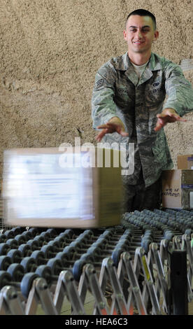 JOINT BASE BALAD, der Irak – Senior Airman Tschad Gogel, 332. Expeditionary Logistik Bereitschaft Squadron inbound Traffic Manager, gleitet ein Paket von Lieferungen an einen Kollegen hier 18 Mai. Inbound Bereich Verkehrsmanagement Büro hier ist verantwortlich für den Empfang und die Trennung von Fracht, verstreut in JBB. Ein Eingeborener von Chandler, Arizona, Airman Gogel ist hier von Fairchild Air Force Base, Washington (U.S. Air Force Photo/Senior Airman Tiffany Trojca) eingesetzt. Stockfoto