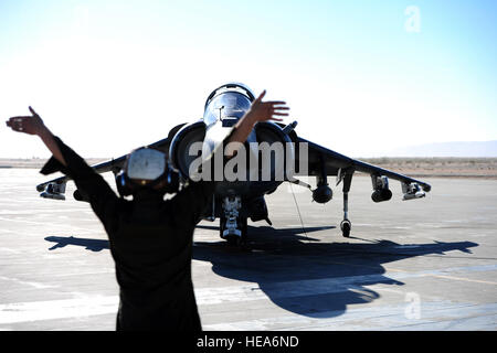 U.S. Marine Corps Lance Cpl. Blake Mullins, Marine Angriff Geschwader 214, Marine Corps Air Station, Yuma, Arizona, signalisiert Generalmajor Casey Elam in ein AV-8 b Harrier für Vorflugkontrollen während integrierte Übung 2-15 im Marine Corps Air Ground Combat Center (MCAGCC) Twentynine Palms, Kalifornien, 17. Februar 2015. MCAGCC führt relevant Leben Feuer kombinierte Waffen training, urbane Operationen und Gelenk/Koalition Integration Ebene Training, das fördert die operativen Kräfte Bereitschaft.  Techn. Sgt. Daniel St. Pierre Stockfoto