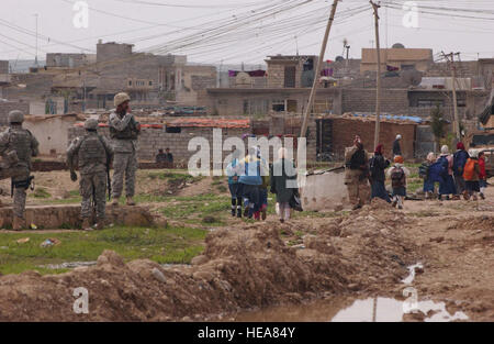 Irakische Kinder Heimweg von der Schule als irakische Polizei und US-Armeesoldaten von Delta Company, 2. Bataillon, 7. Kavallerie-Regiment, 4th Brigade Combat Team, 1. Kavallerie-Division von Fort Bliss, Texas, durchführen eine Patrouille in ihrer Nachbarschaft in Mosul, Irak, 19.März.  Senior Airman Vanessa Valentine) Stockfoto