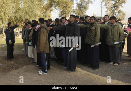 In Kirkuk, Irak, organisierte ein Mitglied der irakischen Polizei Freiwillige aus Hawijah, während Soldaten der US-Armee aus dem 2. Bataillon, dem 27. Infanterieregiment, dem 3. Brigade Combat Team, der 25. Infanteriedivision beobachtet wurden, um Polizeiausbildung und Sicherheitseinsätze zu unterstützen. Stockfoto