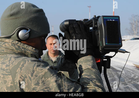 RAMSTEIN AIR BASE, Deutschland--US Air Force Staff Sgt Tiffany Gordon, ein Sender mit American Forces Network Europe, prüft ihre Kameraeinstellungen 4. Dezember 2010, auf der Ramstein Air Base, Deutschland, beim interviewen US Army Major Tim McDonald, der U.S. European Command Logistikleiter, über die Reaktion auf Waldbrände in der Nähe von Haifa, Israel. US Air Forces in Europe begann Luftbrücke 20 Tonnen von feuerhemmenden in einer gemeinsamen Anstrengung die humanitäre Unterstützung im Kampf gegen die schlimmsten Waldbrände in der Geschichte Israels. U.S. European Command kaufte die feuerhemmenden und begann die Mission nach Stockfoto