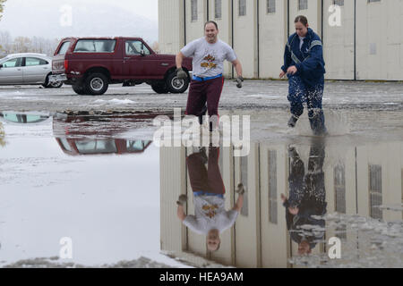 Air Force Reserve Captain Ronald N. Lawrence, Jr. (links), 673rd Air Base Wing Kaplan und Flieger 1. Klasse Andrea Louise Klesser (rechts), 773rd Civil Engineer Squadron-Notfall-Management-Spezialist, beenden die "Ausführen, um bereit zu sein" National Preparedness Day 5K über einer Pfütze auf der gemeinsamen Basis Elmendorf-Richardson 30. September 2015. Die Veranstaltung wird gefördert, indem Informationen und Pfeifen am Ende des Laufs auf Katastrophen vorbereitet. Airman 1st Class Christopher R. Morales) Stockfoto