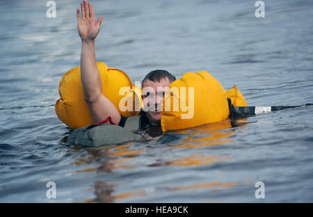 SPC. Lucas Vaughan, ein Eingeborener von Yerington, Nevada, zugewiesen C Truppe, 1st Squadron (Airborne), 40. Kavallerie-Regiment, 4th Infantry Brigade Combat Team (Airborne), 25. Infanterie-Division, U.S. Army Alaska, Wellen, um zu signalisieren, dass er nach einem Sprung ins Big Lake, Alaska, Mittwoch, 6. August 2014, mit t-11 Fallschirme unverletzt ist. Diese Fortbildungsveranstaltung bereitet die Brigade Trooper für potenzielle Wasser Landungen und hebt das Gerät Fähigkeit Luftlandeoperationen unter schwierigen Bedingungen und Standorten überall in der Welt durchführen. Justin Connaher) Stockfoto