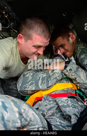 U.S. Air Force Personal Sgts. Steven White und Samuel Taylor, 612th Air Base Squadron Feuerwehrleute, Arbeit, US Air Force Staff Sgt Daniel Easterlund, 612th Air Base Squadron Feuerwehrmann auf einen Wurf während Flugzeuge heben crash Rescue Training auf Soto Cano Air Base, Honduras, 15. Januar 2015. Mindestens einmal pro Quartal, retten die 612th ABS kooperiert mit der 1-228. Aviation Regiment, Flugzeugabsturz zu überprüfen Ausbildung und Notfall Verfahren für den UH-60 Black Hawk-Hubschrauber. Techn. Sgt. Heather Redman) Stockfoto