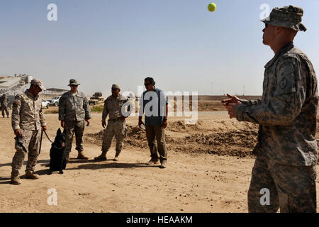 US Armee Sgt. 1. Klasse Seth Murphy, richtig, von Headquarters und Headquarters Company k-9, 1st Stryker Brigade Combat Team, 25. Infanterie-Division, einem irakische Polizisten zeigt, wie man seinen Hund während einer gemeinsamen Übung der k-9 mit irakischen Polizisten aus dem Diyala irakische Polizei Hund Programm auf vorwärts Operating Base War Horse, in der Nähe von Baqouba, Irak, Aug. 2 locken. Stockfoto