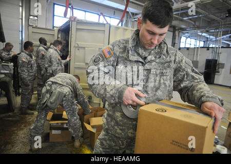 Armee-Personal-Sergeant Barry Joyce, ein Eingeborener von Martinsville, VA., Bänder der Küstenwache Container Inspektion Schulungsteam, eine Feld, um die Batterien zu laden, wie Kameraden 4th Infantry Brigade Combat Team (Airborne), 25. Infanterie-Division, U.S. Army Alaska und Küste Gardisten zugewiesen zugewiesen bereiten Sie Container mit Gefahrgut für den Transport zum Hafen von Anchorage und folgen auf Bewegung in der Joint Readiness Training Center in Fort Polk , La., auf gemeinsame Basis Elmendorf-Richardson, Alaska, 26. Februar 2014.  Justin Connaher Stockfoto