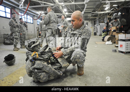 Armee Sgt. 1st Class Randall Summerford, gebürtig aus Oxnard, Kalifornien, Bohrinseln seinen Rucksack für einen Fallschirm zu springen, als Kameraden 4th Infantry Brigade Combat Team (Airborne), 25. Infanterie-Division, U.S. Army Alaska und Küste Gardisten zugewiesen zugewiesen der Coast Guard Container Training Inspektionsteam, bereiten Sie Container mit Gefahrgut für den Transport zum Hafen von Anchorage und folgen Sie auf Bewegung zu den Joint Readiness Training Center in Fort Polk , La., auf gemeinsame Basis Elmendorf-Richardson, Alaska, 26. Februar 2014.  Justin Connaher Stockfoto