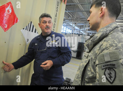 Coast Guard Chief Warrant Officer 4 Bruce Jones, die Coast Guard Container Inspektion Schulungsteam, Gespräche mit Army Staff Sgt Barry Joyce, ein Eingeborener von Martinsville, Virginia, als Soldaten, 4th Infantry Brigade Combat Team (Airborne), 25. Infanterie-Division, U.S. Army Alaska zugewiesen zugewiesen bereiten Sie Container mit Gefahrgut für den Transport zum Hafen von Anchorage und folgen auf Bewegung bis der Joint Readiness Training Center in Fort Polk , La., auf gemeinsame Basis Elmendorf-Richardson, Alaska, 24. Februar 2014.  Justin Connaher Stockfoto