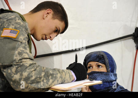 US Army Spc. Maxwell Farmwell, 328. Combat Support Hospital, ruft Patienteninformationen aus einem simulierten schwanger Rollenspieler am Joint Readiness Training Center (JRTC), Fort Polk, Louisiana, 20. Februar 2013. Service-Mitglieder am JRTC 13 / 04 sind in Bekämpfung Patientenversorgung und aeromedical Evakuierung in einer simulierten Kampf Umgebung ausgebildet.  Techn. Sgt. Francisco V. Govea II / veröffentlicht) Stockfoto