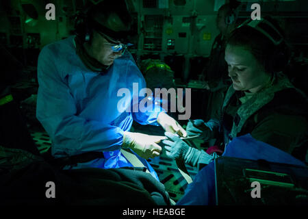 US Air Force Senior Airman Nichole Kilinc, flugmedizinischen Dienst Geselle, 43. Aeromedical Evakuierung-Geschwader, Papst Army Air Field N.C., Leinen US Air Force Oberstleutnant Gerald Fortuna, Unfallchirurgie, 86. Medical Group, Ramstein Air Base, Deutschland, zum Cockpit einer c-17 Globemaster III in Vorbereitung für den Start und sorgte für einen simulierten Patienten am Joint Readiness Training Center (JRTC) , Fort Polk, Louisiana, 18. Januar 2014. Service-Mitglieder am JRTC 14-03 sind in Bekämpfung Patientenversorgung und aeromedical Evakuierung in einer simulierten Kampf Umgebung ausgebildet.  Master Sergeant John R. Nimmo, Sr. /) Stockfoto