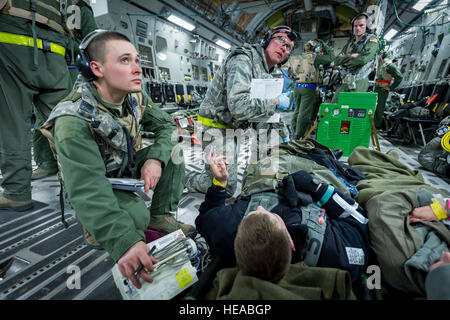 US Air Force Staff Sgt Ksana Bialick, flugmedizinischen Dienst Geselle, 43. Aeromedical Evakuierung-Geschwader, Papst Army Airfield, N.C., und U.S. Air Force Lt. Col Richard Degrosa, Notaufnahme Arzt, 86. Medical Group, Ramstein Air Base, Deutschland, erhalten ein Spritzen von einem Beobachter/Controller, Trainer-Mitglied und sorgte für einen simulierten Patienten an Bord einer c-17 Globemaster III am Joint Readiness Training Center (JRTC) , Fort Polk, Louisiana, 18. Januar 2014. Service-Mitglieder am JRTC 14-03 sind in Bekämpfung Patientenversorgung und aeromedical Evakuierung in einer simulierten Kampf Umgebung ausgebildet.  Master Sergeant John Stockfoto