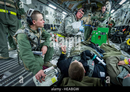 US Air Force Staff Sgt Ksana Bialick, flugmedizinischen Dienst Geselle, 43. Aeromedical Evakuierung-Geschwader, Papst Army Airfield, N.C., und U.S. Air Force Lt. Col Richard Degrosa, Notaufnahme Arzt, 86. Medical Group, Ramstein Air Base, Deutschland, erhalten ein Spritzen von einem Beobachter/Controller, Trainer-Mitglied und sorgte für einen simulierten Patienten an Bord einer c-17 Globemaster III am Joint Readiness Training Center (JRTC) , Fort Polk, Louisiana, 18. Januar 2014. Service-Mitglieder am JRTC 14-03 sind in Bekämpfung Patientenversorgung und aeromedical Evakuierung in einer simulierten Kampf Umgebung ausgebildet.  Master Sergeant John Stockfoto