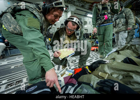 Von links, taktische Intensivpflege expeditionary Team – verbesserte (TCCET-E) Mitglied der US Air Force Captain Richard Rogers, Krankenschwester Anästhesisten, 86. Medical Group, Ramstein Air Base, Deutschland und US Air Force major Corey Norton, Flug Krankenschwester, 43. Aeromedical Evakuierung-Geschwader, Papst Army Airfield, N.C., Rekord Patienten Vitalfunktionen während während des Fluges an Bord einer c-17 Globemaster III am Joint Readiness Training Center (JRTC), Fort Polk , La., 18. Januar 2014. Service-Mitglieder am JRTC 14-03 sind in Bekämpfung Patientenversorgung und aeromedical Evakuierung in einer simulierten Kampf Umgebung ausgebildet.  Master Sergeant John R. Ni Stockfoto